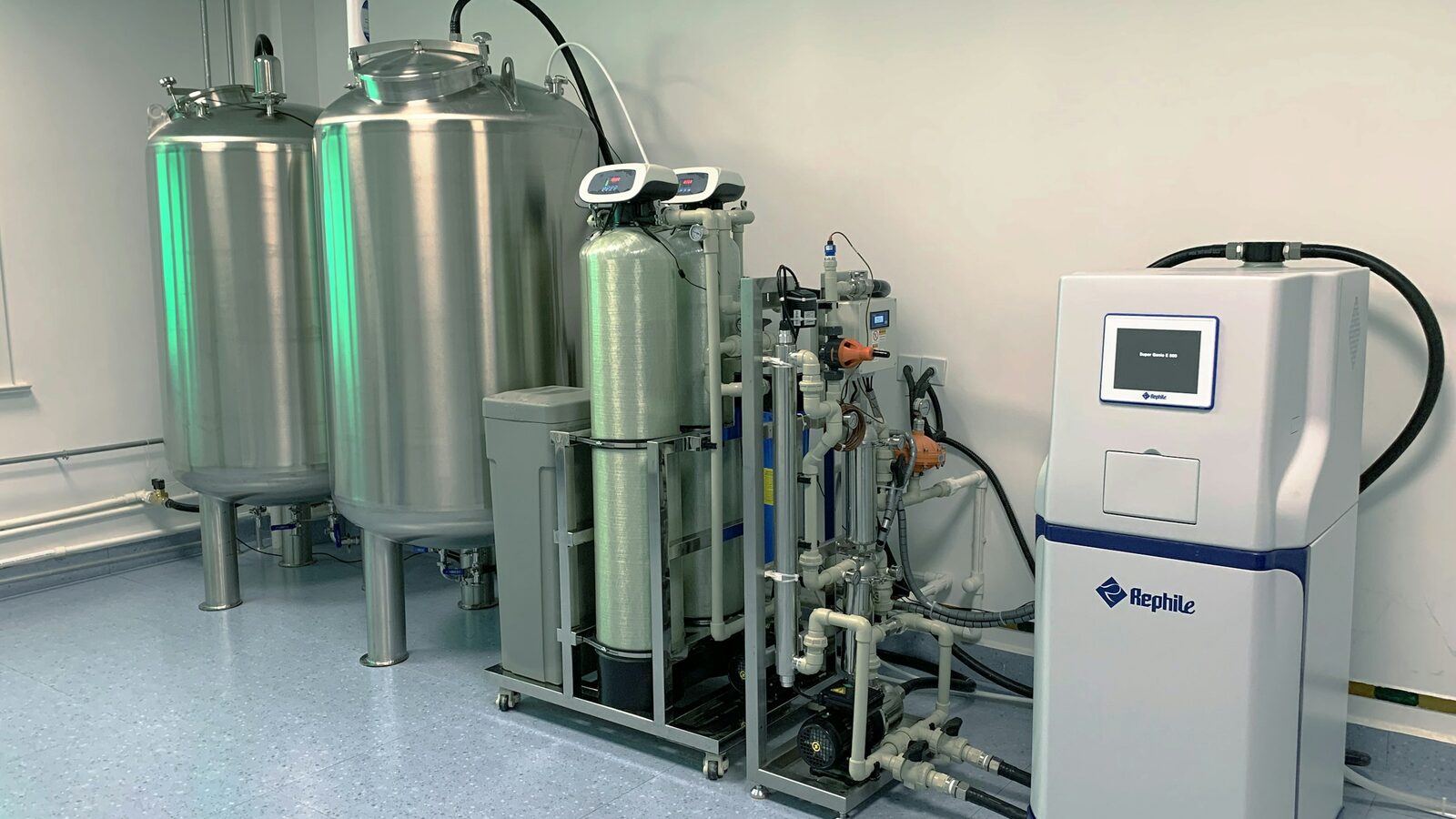Sistema de purificação de água com tanques de inox e painel de controle.