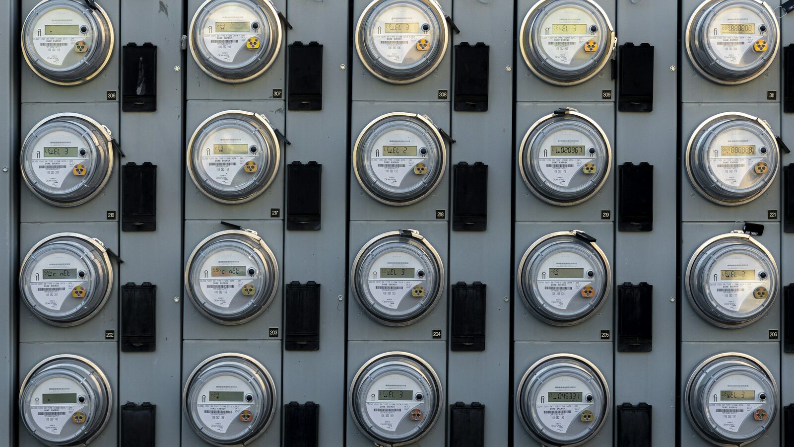 Painel com dezenas de medidores de energia elétrica alinhados.