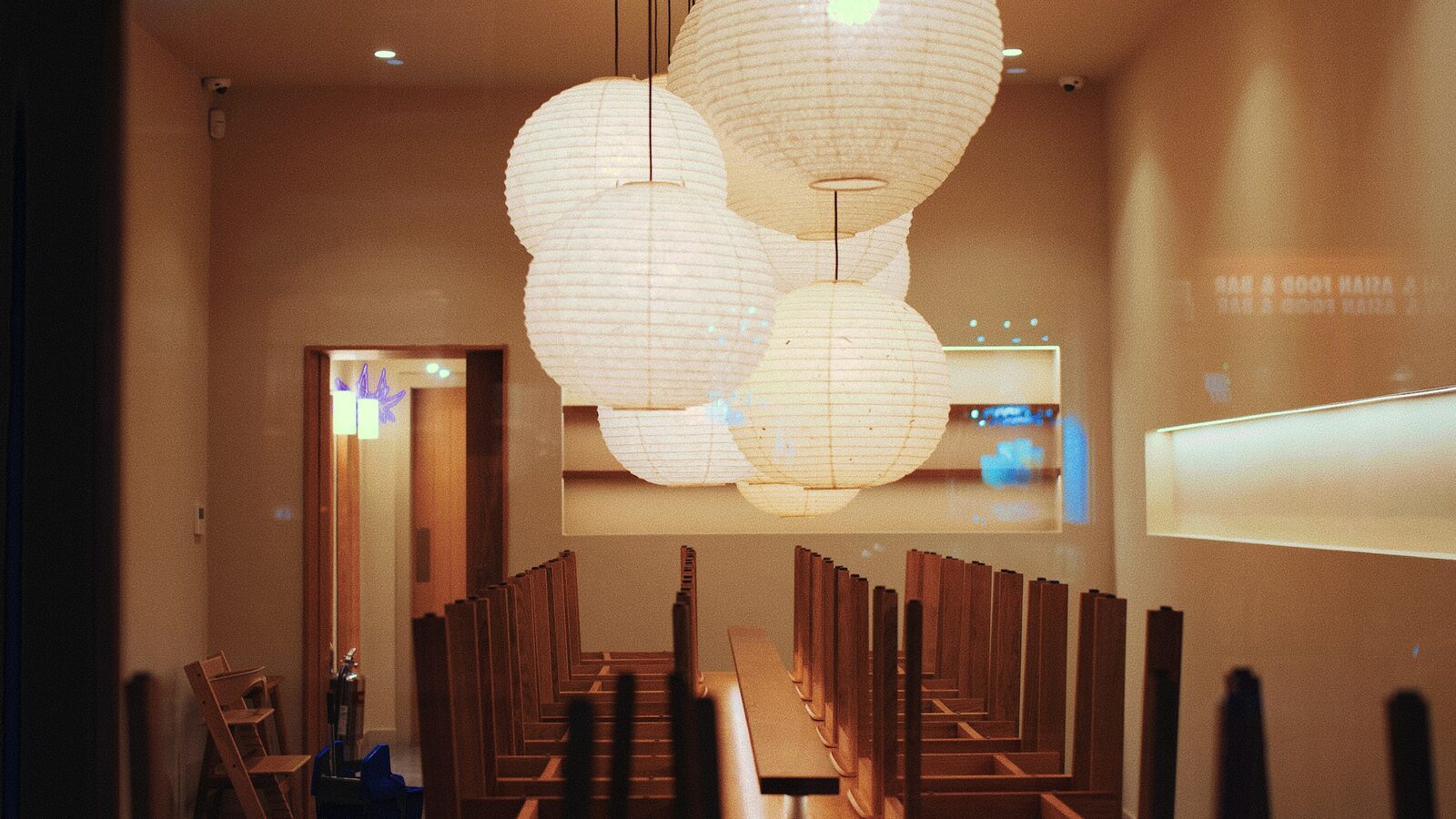 Salão de restaurante vazio, com as cadeiras viradas sobre as mesas.