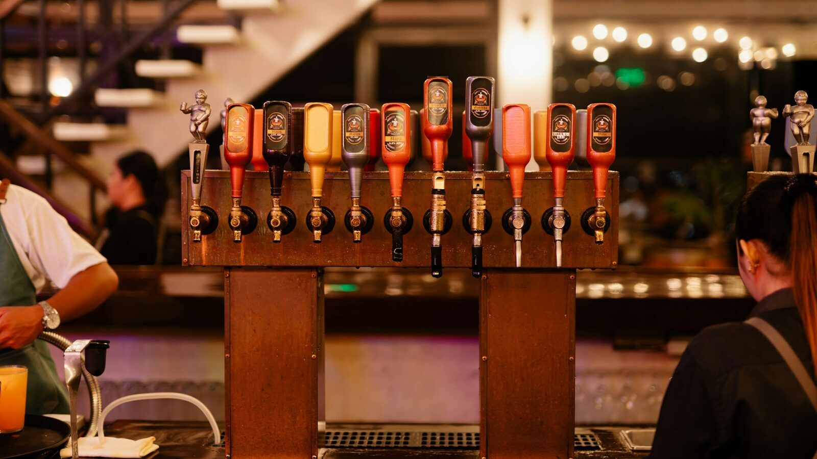Torre de torneiras em estilo chopeira no balcão de um bar.